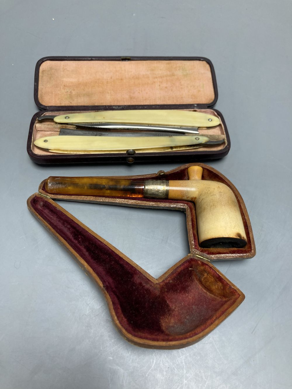A silver-mounted Meerschaum pipe and two cut-throat razors, all cased